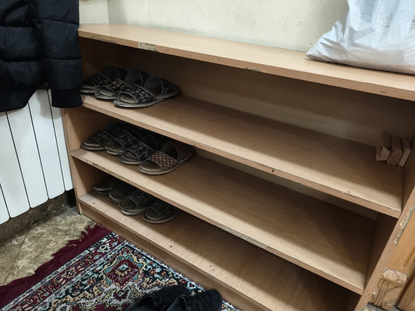 ארונית לנעלי בית לצד דלת הכניסה לבית הכנסת של יהודי ההרים. המתפללים והאורחים מתבקשים לא להיכנס בנעליהם