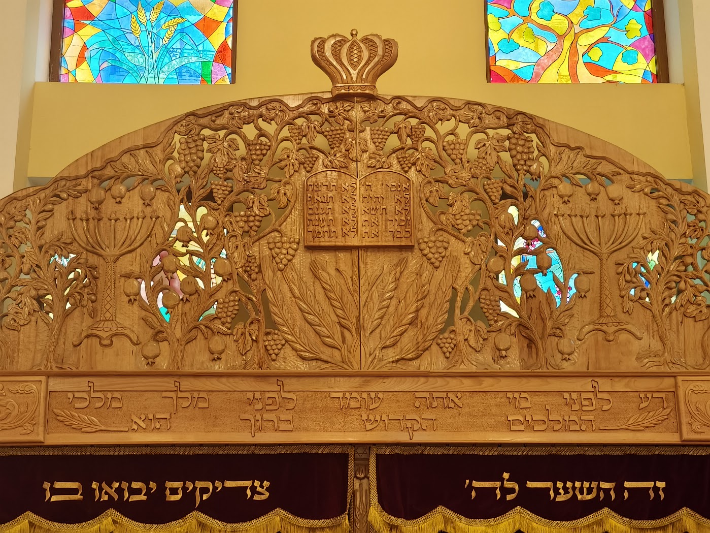 לוח עץ מגולף שניצב מעל ארון הקודש בבית הכנסת של יהודי ההרים