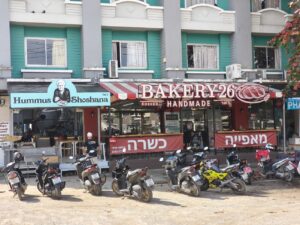 משמאל חומוס שושנה בשכנות למאפיית בייקרי 26